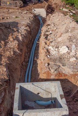 Yere gömülü bir siperde ince kumlu elektrik hatları.