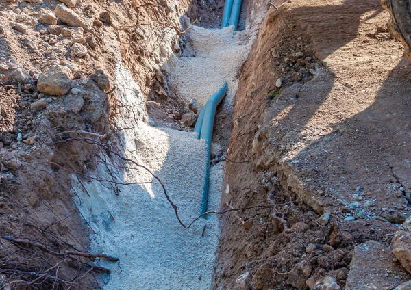 Excavator electrical conduits covered with sand