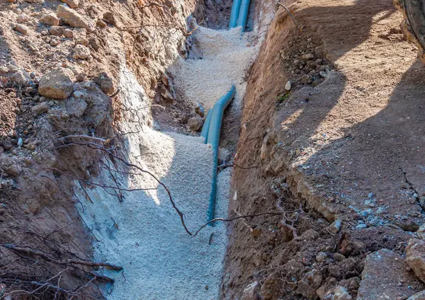 挖掘机电气管道用沙子盖 免版税图库图片