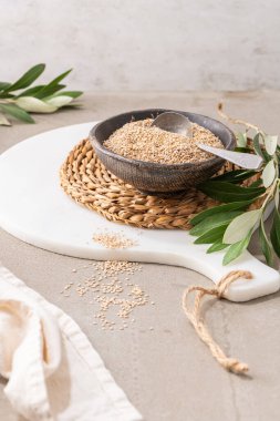 Mutfak tezgahında kaşıkla seramik kasede susam tohumu ya da gergelim. Sağlıklı yemek ve diyet kavramları için. Üst görünüm