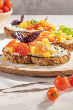 Kızarmış domatesli İtalyan bruschetaları, krem peynir, ananas dilimleri ve mutfak tezgahında otlar. Hizmet etmeye hazır