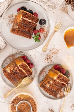 Karamel soslu, böğürtlen ve ahududu ile süslenmiş lezzetli yarı çıplak çikolatalı pasta. Hafif arkaplan