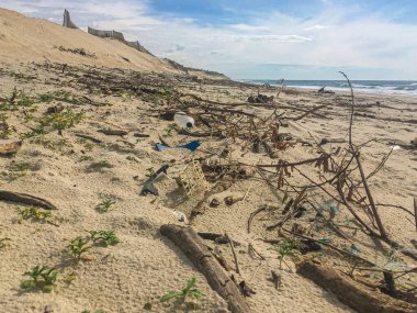 Portekiz, Ovar 'daki Furadouro plajında plastik atık. Çöp, plastik, çöp, şişe ve odun enkazı. Kumsaldaki çevre kirliliği.