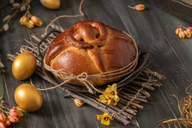 Portuguese traditional Easter cake. Folar with golden eggs on easter table. Blossom flowers and golden painted eggs. clipart