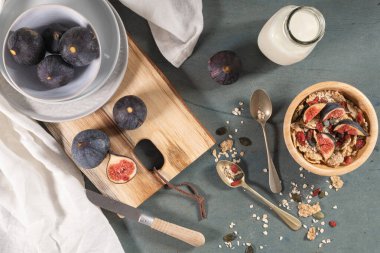Sağlıklı kahvaltı için granola. Tahıl gevreği, süt, taze incir ve kuru böğürtlen kâsesi.