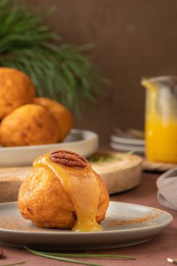 Rabanada 's poveiras with egg cream and cinnamon and pecan nuts on a rustic kitchen counter during the Christmas season.