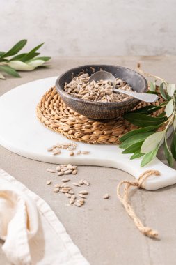 Mutfak tezgahında kaşıkla seramik bir kasede soyulmuş ayçekirdeği. Sağlıklı yemek ve diyet kavramları için..