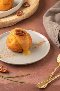 Rabanada 's poveiras with egg cream and cinnamon and pecan nuts on a rustic kitchen counter during the Christmas season.