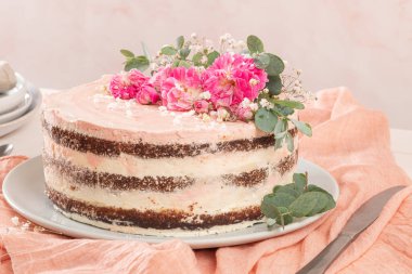 Taze güllerle çikolatalı, çıplak pasta ve beyaz arka planda İsviçre tereyağı.