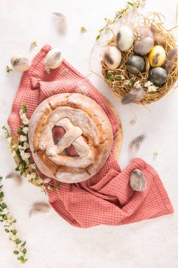 Yumurtalı geleneksel Portekiz Paskalya pastası. Tipik Folar de Vale de Ilhavo, Aveiro, Portekiz. Çiçekler ve renkli boyanmış yumurtalar Paskalya masasında tüylerle süslenmiş.