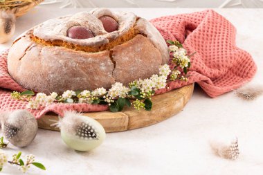 Yumurtalı geleneksel Portekiz Paskalya pastası. Tipik Folar de Vale de Ilhavo, Aveiro, Portekiz. Çiçekler ve renkli boyanmış yumurtalar Paskalya masasında tüylerle süslenmiş.