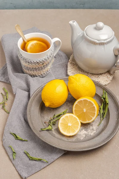 Cup of tea and lemon. A cup of tea with lemon, mint, ginger and honey on on grey table