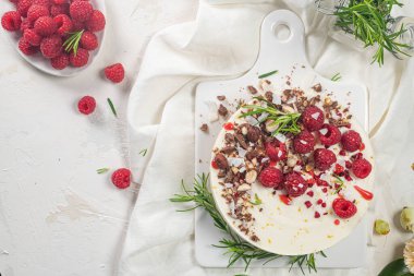 Mutfakta ahududu, çikolata, fındık ve biberiye yapraklı cheesecake.