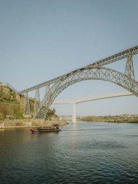 Geleneksel yelkenli şarap teknesi gezisi ile Douro nehri Maria Pia ve Sao Joao köprüleri manzarası, Sunhine 'deki çağlayan konutların tipik mimarisi. Douro Nehri 'ndeki Rabelo teknesi, Porto, Portekiz