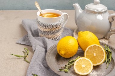 Cup of tea and lemon. A cup of tea with lemon, mint, ginger and honey on on grey table