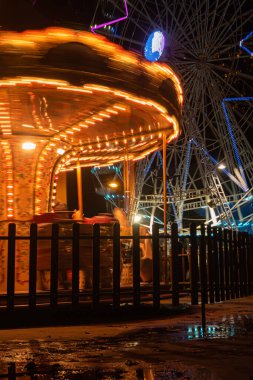 AVEIRO, PORTUGAL - CIRCA Aralık 2018: Noel pazarlı Fonte Nova 'nın bahçesi ve gece Ria de Aveiro yakınlarında renkli atlıkarınca.
