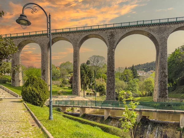 Vouzela, Viseu, Portekiz 'deki eski demiryolu köprüsü ve bahçesi güneşli bir öğleden sonra.