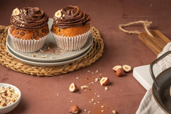 Çikolata parçalı kekler çikolata ganache ve fındıkla süslenmiş mutfak tezgahında..