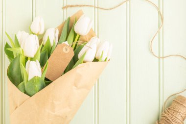 Yeşil ahşap arka planda beyaz lale buketi, kopyalama alanı. Paskalya. Üst görünüm