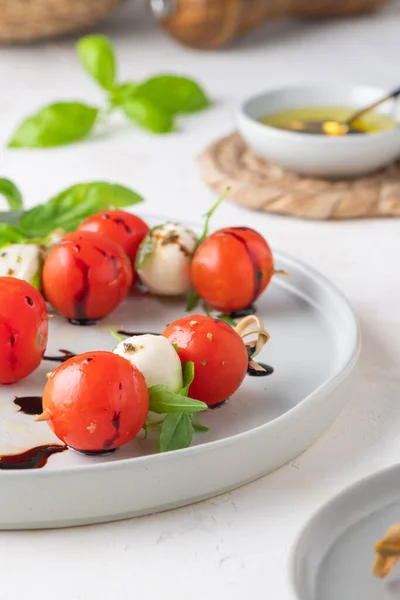 Caprese Spiesjes Met Tomaten Mozzarella Ballen Basilicum Specerijen Witte Tafel — Stockfoto