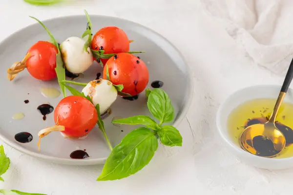 Caprese Szaszłyki Pomidorami Kulki Mozzarella Bazylia Przyprawy Białym Stole Zbliżenie — Zdjęcie stockowe
