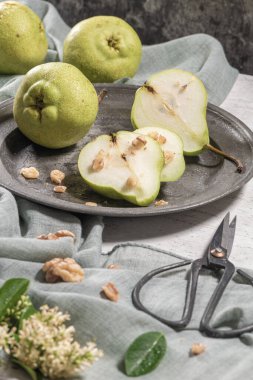 Fındık ile lezzetli armut. Çiçeklerle süslenmiş bir masa ve plakaya kesilmiş bir tabak armut