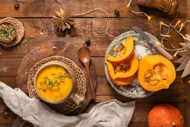 Lezzetli balkabağı kremalı çorba, organik bitkiler ve kabak tohumları eski seramik kasede. Sonbahar sıcacık akşam yemeği konsepti