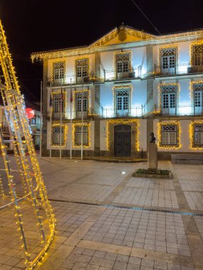 Oliveira de Azemeis, Portekiz - Aralık 12023. Noel ışıklarıyla süslenmiş eski şehir sokaklarına bir aylağın bakış açısı.