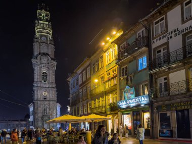 Porto, Portekiz - 9 Aralık 2023. İkonik Clerigos Kulesi ve kilise, şehrin simgeleri ve simgelerinden biri. Unesco Dünya Mirası Alanı. Gece sahnesi.