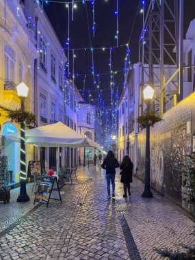 Aveiro, Portekiz - 10 Aralık 2023. Eski sokakların gece manzarası. Yöre sakinleri ve ziyaretçiler Noel ışıklarını görmek için sokaklarda yürüyorlar.