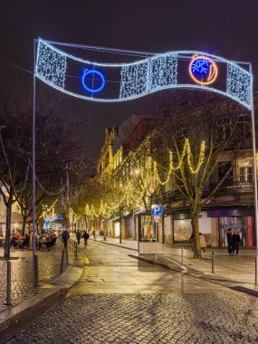 Porto, Portekiz - 9 Aralık 2023. Carmelitas Caddesi 'nin gece manzarası. Yöre sakinleri ve ziyaretçiler Noel ışıklarını ve belediye binasının önündeki büyük Noel ağacını görmek için caddelerde yürüyorlar.