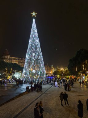 Porto, Portekiz - 9 Aralık 2023. Avenida dos Aliados ve Belediye Binası 'nın gece sahnesi Noel ağacıyla. Yöre sakinleri ve ziyaretçiler Noel ışıklarını ve belediye binasının önündeki büyük Noel ağacını görmek için caddelerde yürüyorlar.