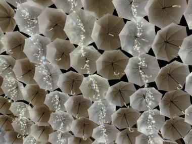 Porto, Portekiz - 8 Aralık 2023. Agueda Portekiz sokaklarını süsleyen Noel ışıklarıyla aydınlanan beyaz şemsiyelerin güzelliği