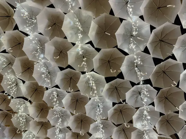 Porto, Portekiz - 8 Aralık 2023. Agueda Portekiz sokaklarını süsleyen Noel ışıklarıyla aydınlanan beyaz şemsiyelerin güzelliği