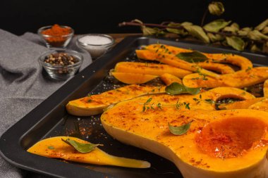 Fırında pişirmek için hazırlanmış bir sürü parlak balkabağı dilimi..