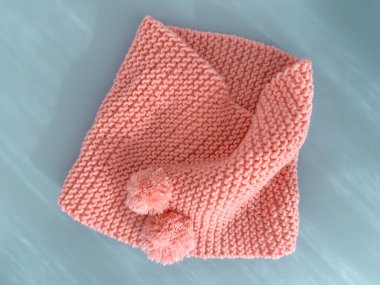 Yumuşak pembe dantel örülmüş yuvarlak eşarp pastel mavi arka planda izole edilmiş. Moda çocuk aksesuarı.