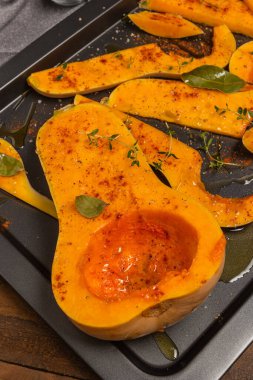 Fırında pişirmek için hazırlanmış bir sürü parlak balkabağı dilimi..