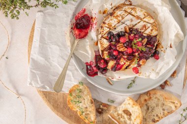 Kırmızı meyve reçeli eklenmiş fırında peynirli camembert peyniri. Üst Manzara. Düz katman