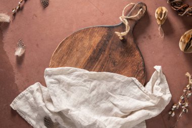 Paskalya süslemeleri, söğüt dalları, kağıt yumurtalar ve paskalya bayramı süslemeleri olan mutfak masasının tahtasını kesmek. Üst manzara, Paskalya bayramı kompozisyonu. Düz yatıyordu