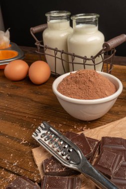 Koyu ahşap masada çikolatalı kek pişirmek için ürünler ve eşyalar. Ev yapımı kavramı.
