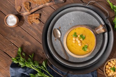 Kahverengi ahşap arka planda balkabağı ve nohut çorbası. Üst görünüm