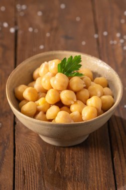 Maydanoz yaprağıyla dekore edilmiş, seramik bir kasede nohut pişirilmiş, yemeye hazır.