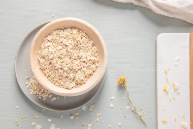 Yuvarlanmış yulaf veya açık mavi arka planda seramik kasede yulaf ezmesi. Sağlıklı yaşam tarzı, sağlıklı beslenme, diyet, kilo verme. Sağlıklı beslenme ve beslenme kavramı. Üst görünüm, kopyalama alanı ile.