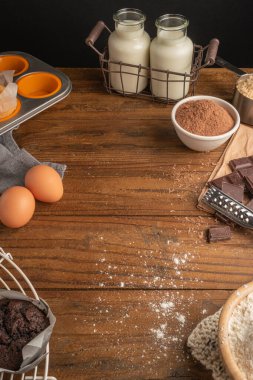 Koyu ahşap masada çikolatalı kek pişirmek için ürünler ve eşyalar. Ev yapımı kavramı.