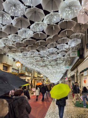 Porto, Portugal - December 8, 2023. The beauty of white umbrellas iluminated by Christmas lights decorating the streets of Agueda Portugal clipart