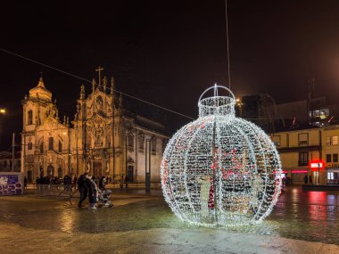 Porto, Portekiz - 9 Aralık 2023. Aslan çeşmesinin gece sahnesi. Yöre sakinleri ve ziyaretçiler Noel ışıklarını ve belediye binasının önündeki büyük Noel ağacını görmek için caddelerde yürüyorlar.