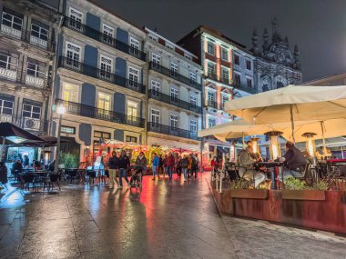 Porto, Portekiz - 9 Aralık 2023. Porto 'daki Rua das Flores ya da Flores caddelerinin Noel süslemeleriyle süslendiği gece sahnesi. Yöre sakinleri ve ziyaretçiler Noel ışıklarını görmek için sokaklarda yürüyorlar.