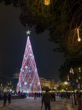 Porto, Portugal - December 9, 2023. Night scene of Avenida dos Aliados and City Hall with Christmas tree. Residents and visitors walk the streets to see the Christmas lights and the large Christmas tree installed in front of the City Hall clipart