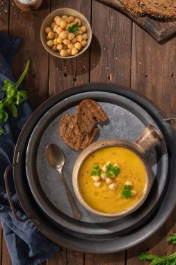 Kahverengi ahşap arka planda balkabağı ve nohut çorbası. Üst görünüm