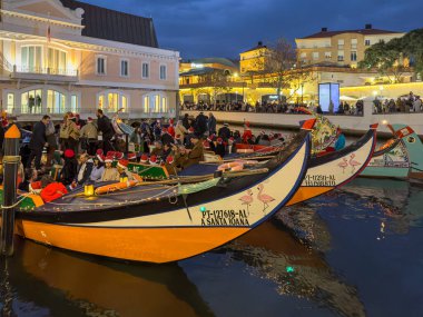 Aveiro, Portugal - December 01, 2023. A moliceiro boat, adorned with lights and carrying festive passengers, cruises along the illuminated canals of Aveiro, Portugal, creating a magical Christmas atmosphere. clipart